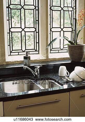 Close-up of leaded windows above underset stainless steel sinks in granite worktop View Large Photo Image Stock Image - Close-up of leaded windows above underset stainless steel sinks in granite worktop. Fotosearch