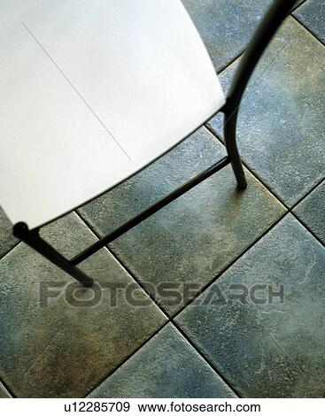 Close-up of modern chair on grey floor tiles View Large Photo Image Stock Photo - Close-up of modern chair on grey floor tiles. Fotosearch