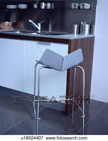Close-up of modern steel stool on limestone tiles in modern kitchen View Large Photo Image Stock Photo - Close-up of modern steel stool on limestone tiles in modern kitchen. Fotosearch
