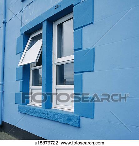 Stock Image - Close-up of modern window in blue house. Fotosearch