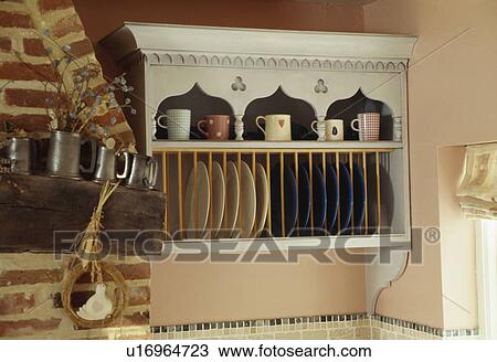 Stock Image - Close-up of painted cupboard with plate rack. Fotosearch
