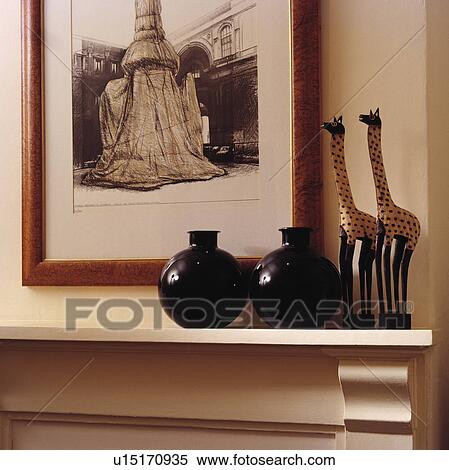 Close-up of picture above black vases and wooden giraffes View Large Photo Image Stock Photography - Close-up of picture above black vases and wooden giraffes. Fotosearch