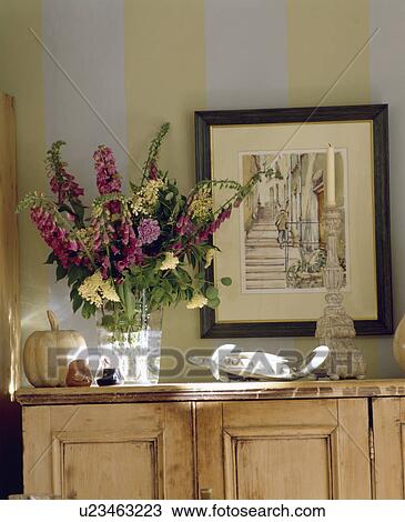 Close-up of picture above foxgloves in vase on pine cupboard View Large Photo Image Stock Image - Close-up of picture above foxgloves in vase on pine cupboard. Fotosearch