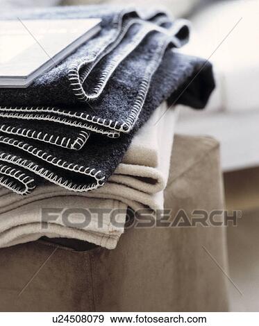 Stock Photo - Close-up of pile of grey and cream blankets. Fotosearch