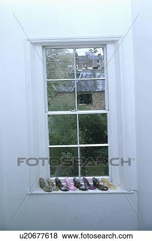 Stock Photo - Close-up of sash window with shoes on windowsill. Fotosearch