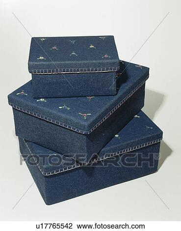 Stock Image - Close-up of set of 3 denim storage boxes decorated with floral motif. Fotosearch