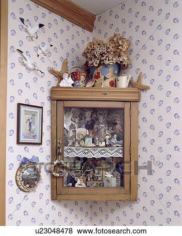 Close-up of small corner cupboard with collection of nautical ornaments View Large Photo Image Stock Photo - Close-up of small corner cupboard with collection of nautical ornaments. Fotosearch