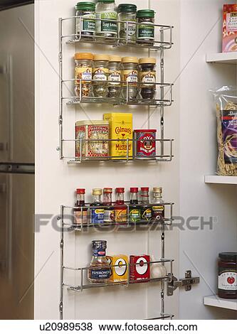 Close Up Of Spice Jars On Metal Rack On The Back Of Cupboard Door