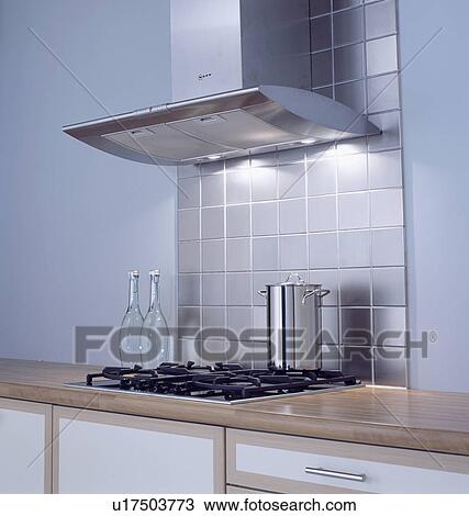 Close-up of steel extractor and stainless steel wall tiles above tall pan on hob View Large Photo Image Stock Image - Close-up of steel extractor and stainless steel wall tiles above tall pan on hob . Fotosearch