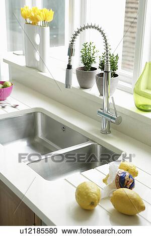 Close-up of steel swivel mixer tap and double stainless steel underset sink with lemons on draining board View Large Photo Image Stock Image - Close-up of steel swivel mixer tap and double stainless steel underset sink with lemons on draining board. Fotosearch