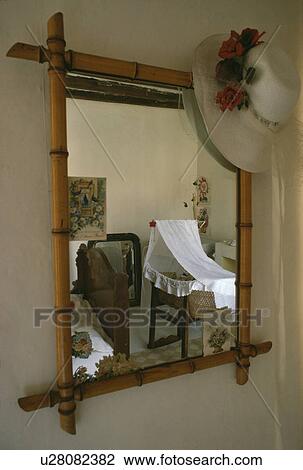 Close-up of straw hat on bamboo mirror with reflection of baby's cot in child's nursery bedroom View Large Photo Image Stock Image - Close-up of straw hat on bamboo mirror with reflection of baby's cot in child's nursery bedroom. Fotosearch