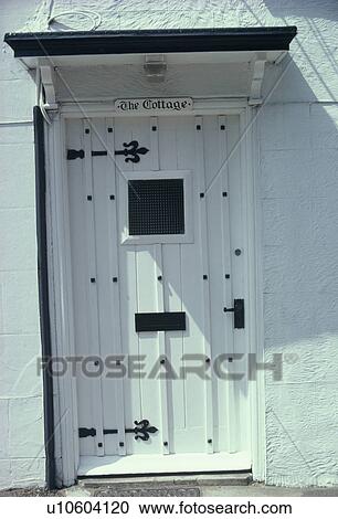 Stock Image - Close up of traditional white front door with small window. Fotosearch