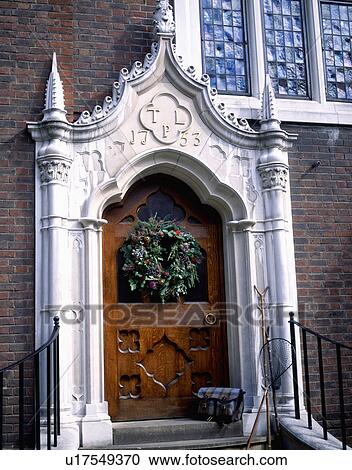 Stock Image - Close-up of traditional wooden front door with ornate Gothic stone porch. Fotosearch