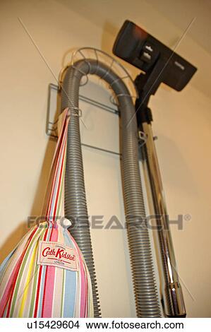 Close up of vacuum cleaner stored on wall with Cath Kidston bag View Large Photo Image Picture - Close up of vacuum cleaner stored on wall with Cath Kidston bag. Fotosearch