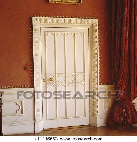 Close up of white Gothic door with ornately carved frame in red room with white wainscot panelling and red curtain View Large Photo Image Stock Image - Close up of white Gothic door with ornately carved frame in red room with white wainscot panelling and red curtain. Fotosearch