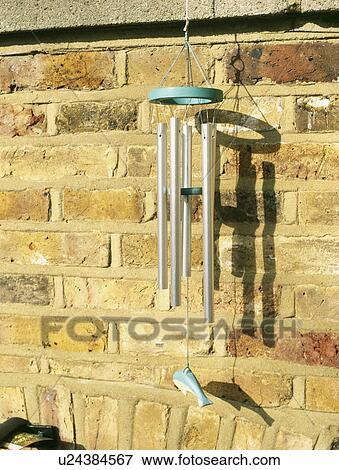 Close up of windchime on brick wall View Large Photo Image Stock Photo - Close up of windchime on brick wall. Fotosearch