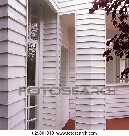 Stock Image - Closeup of exterior of house with white plastic cladding. Fotosearch