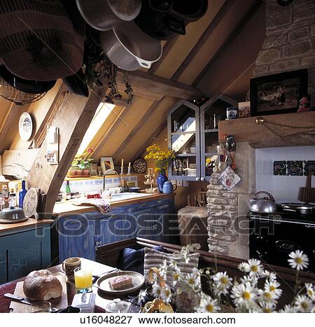 Cluttered attic kitchen with distressed paint effect blue fitted cupboards View Large Photo Image Stock Photo - Cluttered attic kitchen with distressed paint effect blue fitted cupboards . Fotosearch