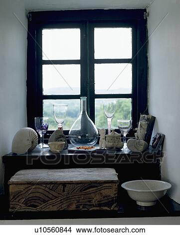 Picture - Collection of glassware and found objects on recessed windowsill. Fotosearch