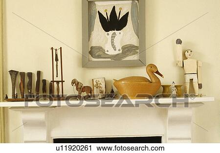 Stock Image - Collection of old wooden toys on mantelpiece below picture. Fotosearch