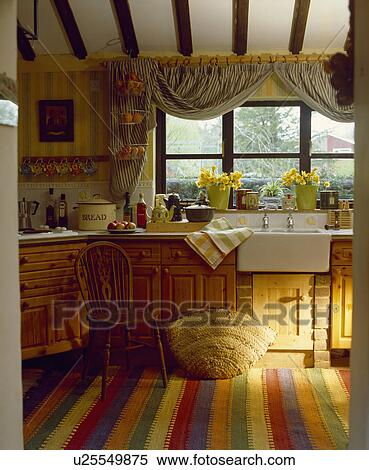 Colourful striped rug on floor below ceramic sink in cottage kitchen with view through the window View Large Photo Image Stock Photography - Colourful striped rug on floor below ceramic sink in cottage kitchen with view through the window. Fotosearch