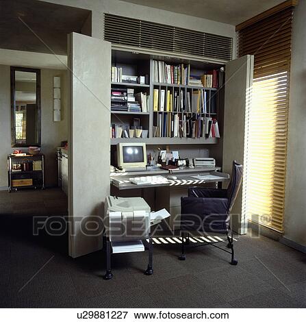 Compact home office can be hidden away behind double doors in city apartment View Large Photo Image Stock Photo - Compact home office can be hidden away behind double doors in city apartment. Fotosearch