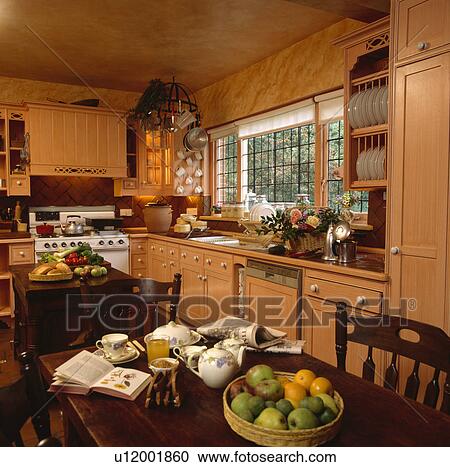 Cookery book and fruit on table in peach kitchen with paint effect marbling on walls View Large Photo Image Stock Image - Cookery book and fruit on table in peach kitchen with paint effect marbling on walls. Fotosearch