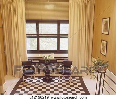 Cream Curtains And Slatted Blind On Large Window In Hall With