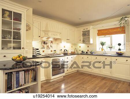 Cream Fitted Cupboards With Black Granite Worktops In Contemporary