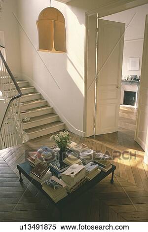 Cream lampshade above books on table on landing with parquet floor View Large Photo Image Stock Photography - Cream lampshade above books on table on landing with parquet floor. Fotosearch