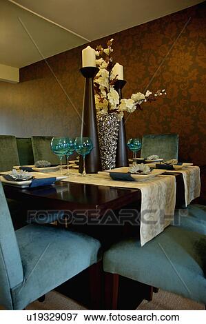 Cream runners and table settings with tall candles in modern dining room with upholstered blue chairs View Large Photo Image Stock Photo - Cream runners and table settings with tall candles in modern dining room with upholstered blue chairs. Fotosearch