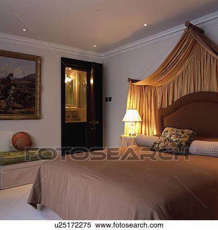 Cream Silk Drapes Above Bed With Brown Silk Upholstered Headboard