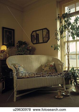 Stock Photo - Cream wicker sofa in traditional living room. Fotosearch