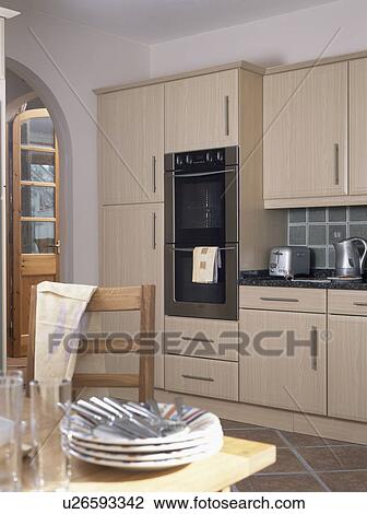 Cutlery and plates on table in modern kitchen with light wood units View Large Photo Image Stock Image - Cutlery and plates on table in modern kitchen with light wood units. Fotosearch