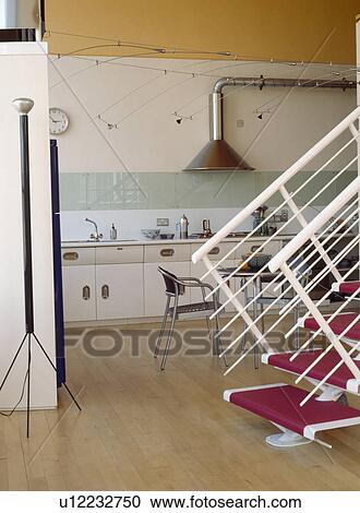 Stock Image - Cylindrical lamp in loft conversion kitchens with wooden flooring and metal staircase . Fotosearch