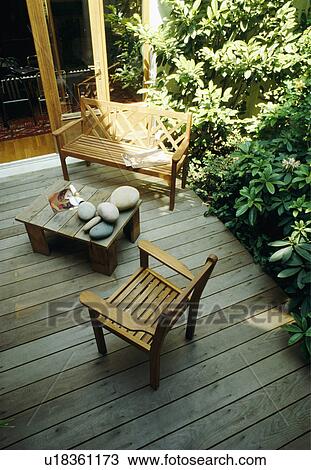 Stock Image -  Decked patio with mature rhododendrons . Fotosearch