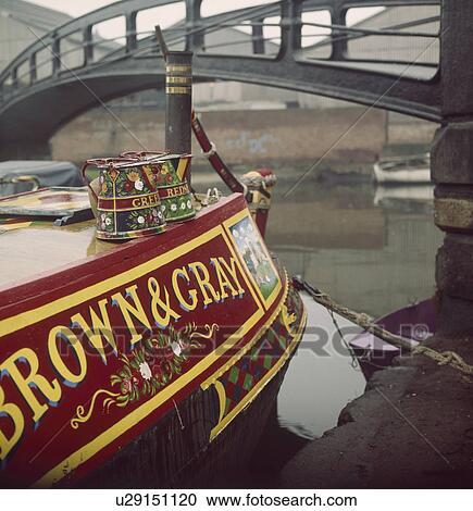 Decorated water cans and sign painting on traditional narrow boat moored below canal bridge View Large Photo Image Stock Image - Decorated water cans and sign painting on traditional narrow boat moored below canal bridge. Fotosearch