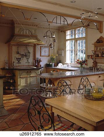 Decorative metal decoration below ceiling in traditional kitchen with metal chairs at pine table View Large Photo Image Stock Photography - Decorative metal decoration below ceiling in traditional kitchen with metal chairs at pine table. Fotosearch