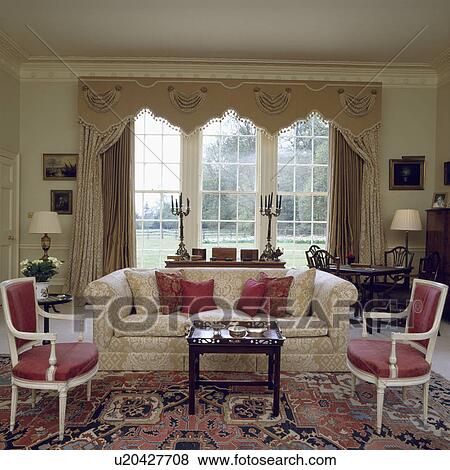 Decorative pelmet and neutral curtains in traditional living room with cream sofa and patterned carpet View Large Photo Image Stock Photo - Decorative pelmet and neutral curtains in traditional living room with cream sofa and patterned carpet . Fotosearch