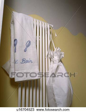 Stock Image - Detail showing white towel rail against yellow and grey painted wall. Fotosearch