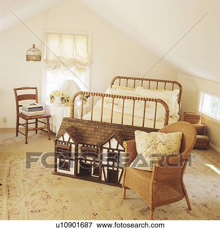 Dolls house in front of bed with barleytwist spindles in attic bedroom with wicker armchair and floral carpet View Large Photo Image Stock Photo - Dolls house in front of bed with barleytwist spindles in attic bedroom with wicker armchair and floral carpet. Fotosearch