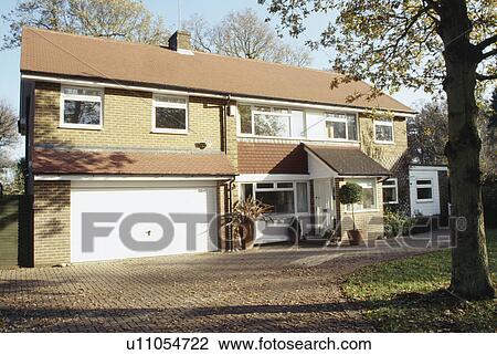 Stock Image - Drive in front of newbuild house with integral garage. Fotosearch