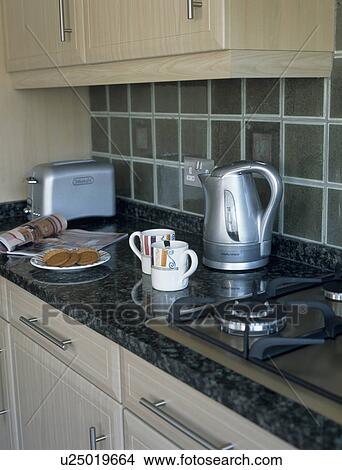 Picture - Electric kettle and cups on granite worktop in modern kitchen. Fotosearch