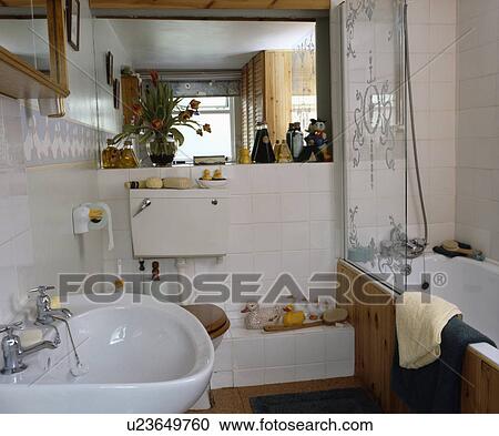 Stock Image - Engraved glass panel on bath in small family bathroom. Fotosearch