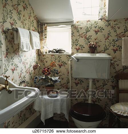 Stock Photograph - Floral patterned wallpaper in small attic bathroom . Fotosearch