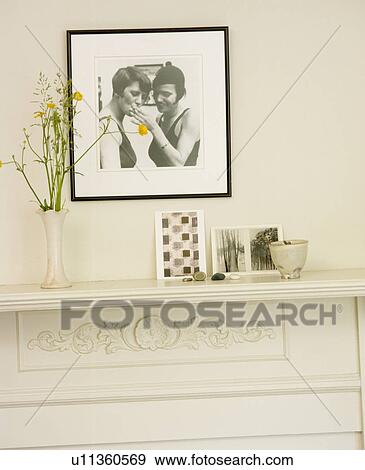 Stock Photo - Framed black and white thirties photograph above white mantelpiece. Fotosearch