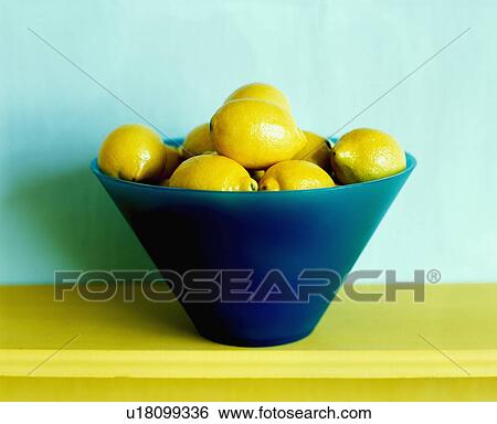 Stock Photograph - Fresh lemons in blue glass bowl. Fotosearch