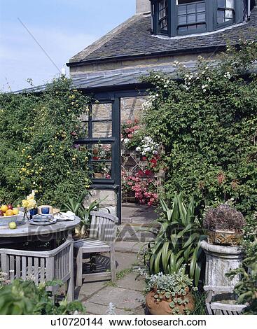 Picture - Furniture on patio in country garden in summer. Fotosearch