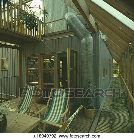 Stock Image - Furniture on patio in country garden in summer. Fotosearch