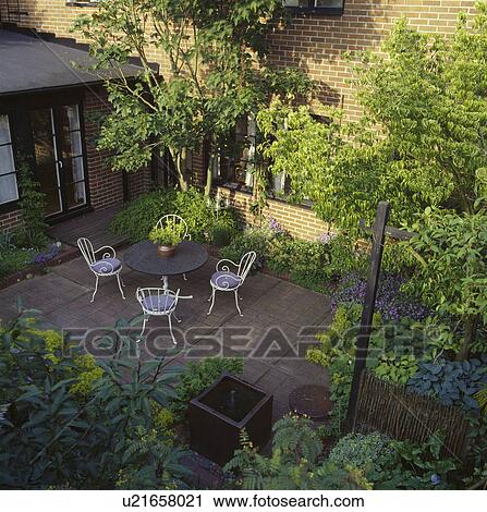 Stock Image - Furniture on patio in town garden in summer. Fotosearch